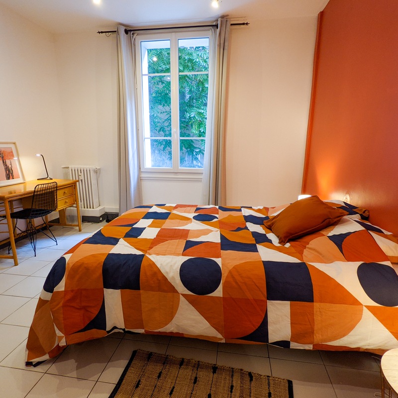 Chambre terracotta mur orange lit double et bureau en rotin — Coliving centre-ville Toulon
