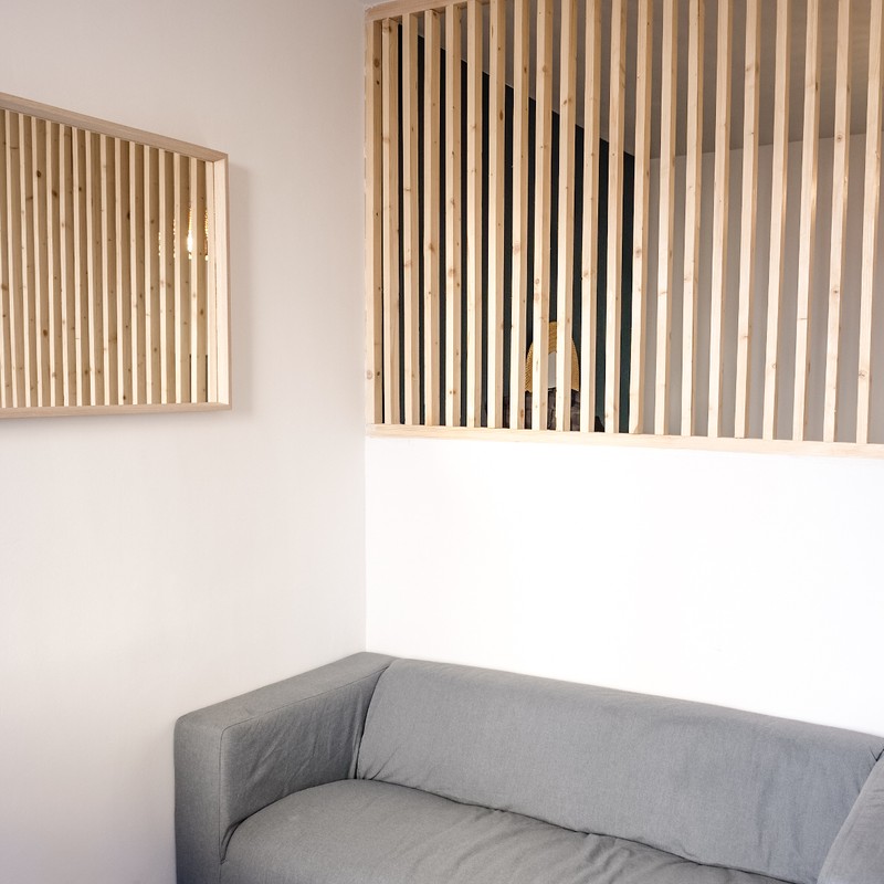 Salon cosy avec canapé gris et claustra bois — Studio Mourillon