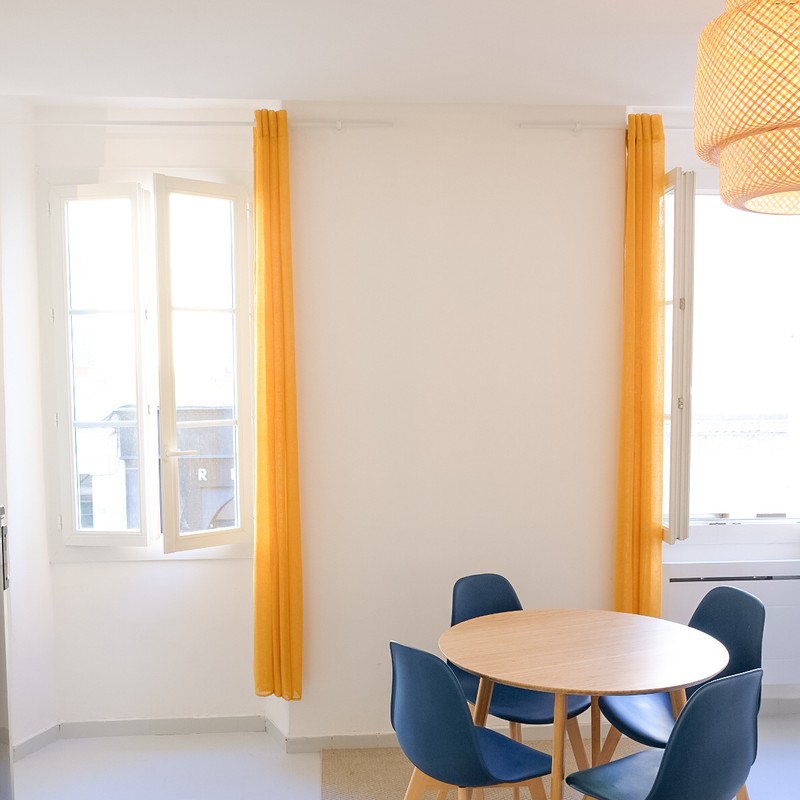 Séjour baigné de lumière avec rideaux jaunes — Studio étudiant Toulon
